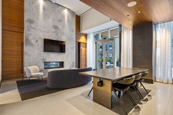 A dining room with a table and chairs and a stone fireplace